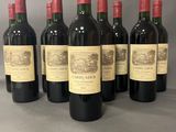 six bouteilles de vin rouge sont alignées sur une table