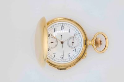 a gold pocket watch on a white surface