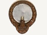 a mirror on the wall with a candle in it