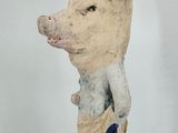statue of a pig in a blue pants and a white shirt
