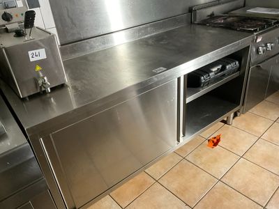 a large stainless steel kitchen with a stove and oven