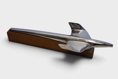 a silver airplane on a wooden stand on a white background