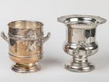 two silver vases sitting next to each other on a table