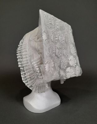 sculpture blanche représentant une tête surmontée d'un voile