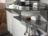 many pots and pans on the shelves in the kitchen