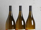 trois bouteilles de vin posées sur une table en bois