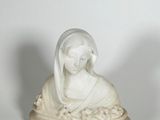 statue d'une femme, la tête voilée, assise sur un rocher