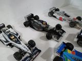 quatre voitures de course exposées dans une vitrine