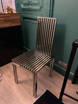 une chaise en métal posée devant un piano