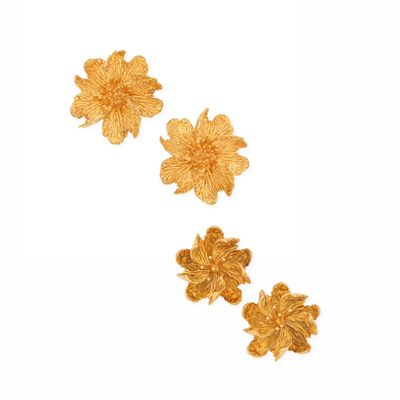 a close up of three gold flowers on a white background