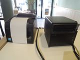 two printer machines sitting on a table in a room