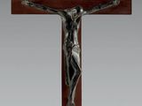 un crucifix en bronze sur une croix en bois, sur fond blanc