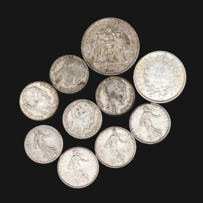 Plusieurs pièces d'argent sont disposées en cercle sur une surface noire