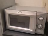 un micro-ondes posé sur un réfrigérateur dans une cuisine