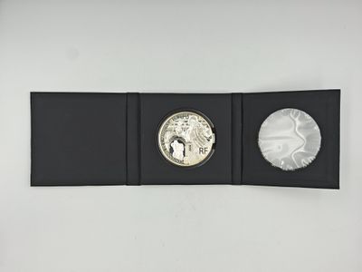 a close up of a coin in a black box on a white surface
