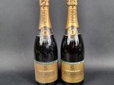 two bottles of champagne sitting next to each other on a table