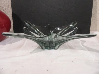 a glass bowl on a table with a red apple in the background