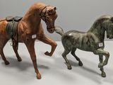 two figurines of horses that are standing next to each other