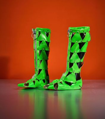 pair of green boots with black and white triangles on them