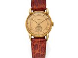 a gold wrist watch with a brown leather strap