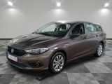 La voiture marron est garée sur un sol en carrelage à damier.