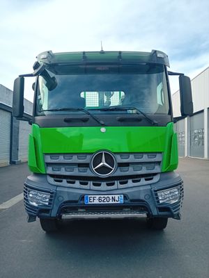 un camion vert qui roule dans la rue