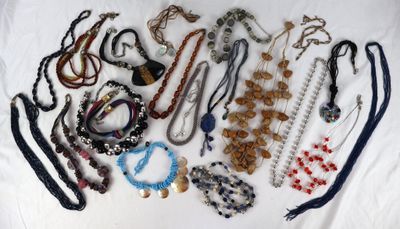 de nombreux colliers et bracelets disposés sur un lit