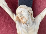 a statue of jesus on a cross on a red wall