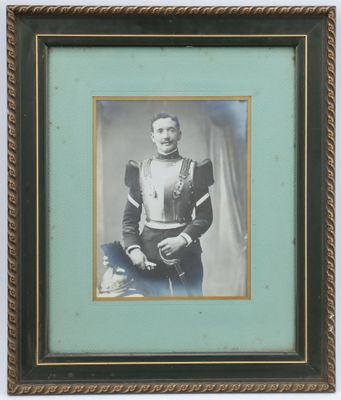 an old photo of a man in a military uniform holding a rifle
