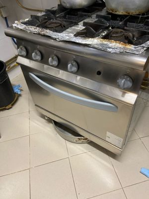 une cuisinière sur laquelle est posée une marmite dans une cuisine