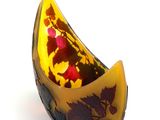 a yellow and black bowl with a red flower inside of it