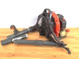 a picture of a chainsaw and a blower on a wooden table