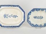 two blue and white plates with designs on them on a white surface