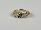 une bague en or jaune sertie d'un saphir bleu et de saphirs taille baguette
