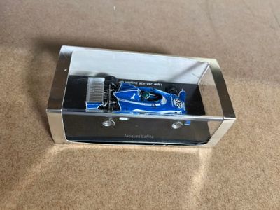 a blue toy car in a clear box on the floor