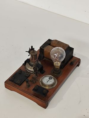 une petite horloge posée sur une table, surmontée d'une ampoule
