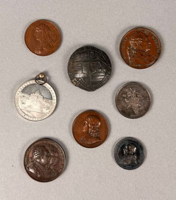 several different coins are arranged in a circle on a white surface