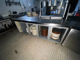 une photo d'une cuisine avec de nombreuses casseroles et poêles posées sur le plan de travail