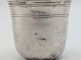 an antique silver cup on a white surface with a white background