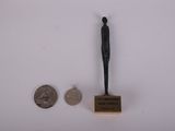 une petite statue représentant un homme debout à côté d'un penny