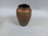 a brown vase sitting on a white surface