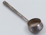 an old spoon with a metal handle sitting on a white surface