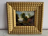 cadre doré avec un tableau représentant un homme et une femme dans un paysage