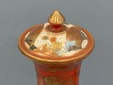 a vase with a lid that has a design on it