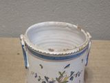 a white vase with a blue handle sitting on a table