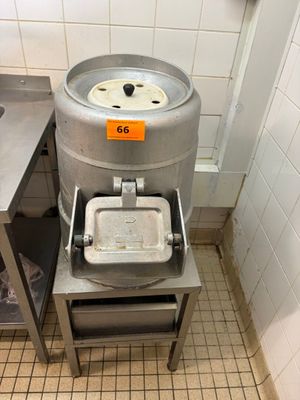 une photo d'un coin cuisine avec un évier et un grand tonneau en métal