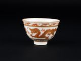 un bol orange et blanc orné d'un motif représentant un dragon