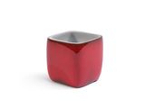 a small red bowl sitting on top of a white surface