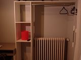 a small room with a desk and a tv on the wall