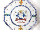 a plate with a coat of arms on it next to a clock